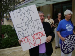 Florida NOW Pres. Donna Slutiak, holding sign, and past Florida NOW Pres. Clarice Pollock